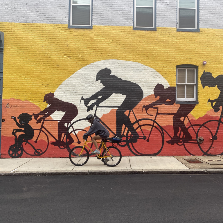 person biking in front of a mural of bikers