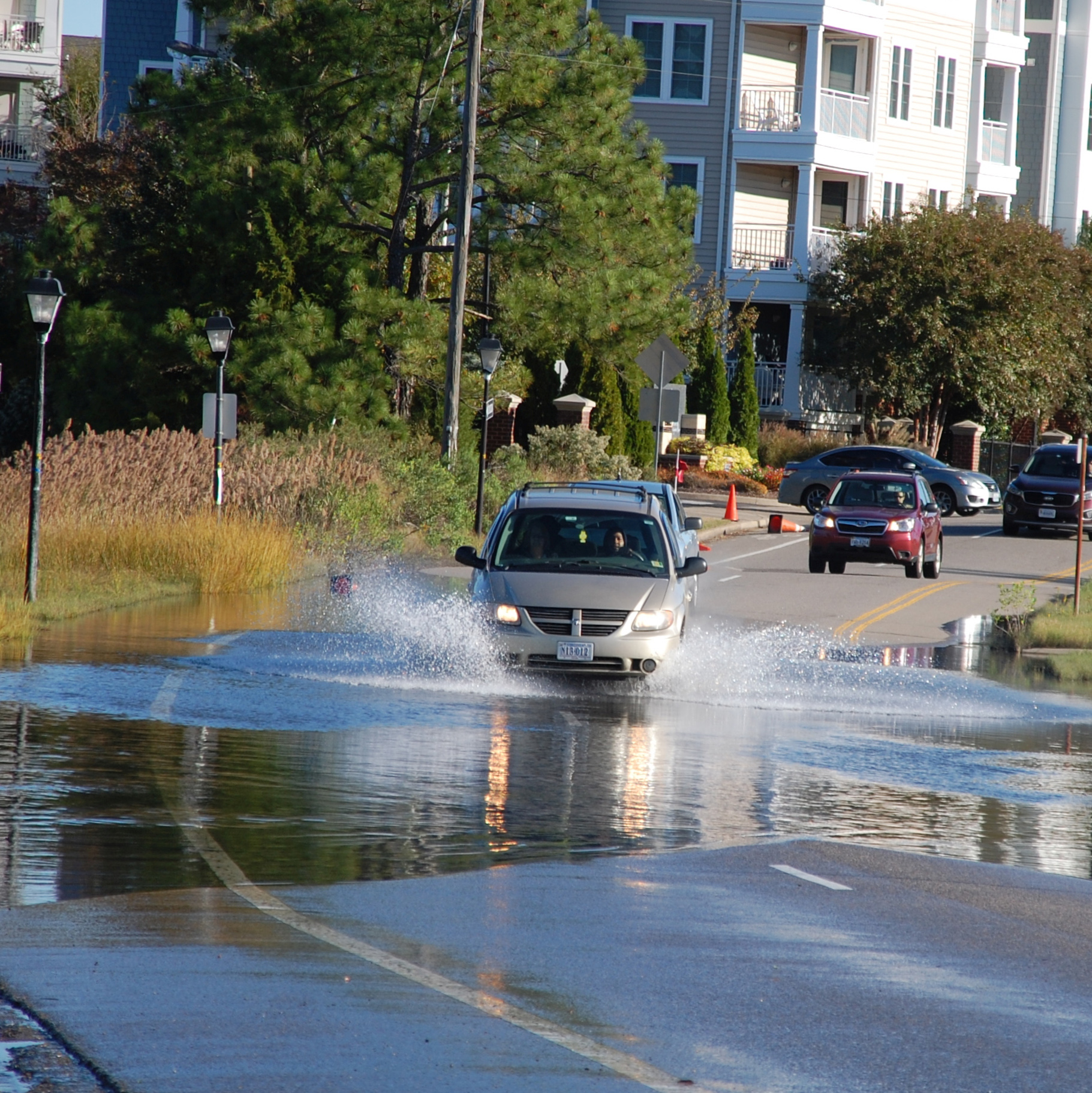 Van driving through water covering the road